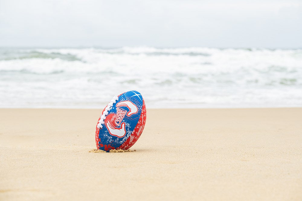 Ein roter Strandfußball liegt am Strand